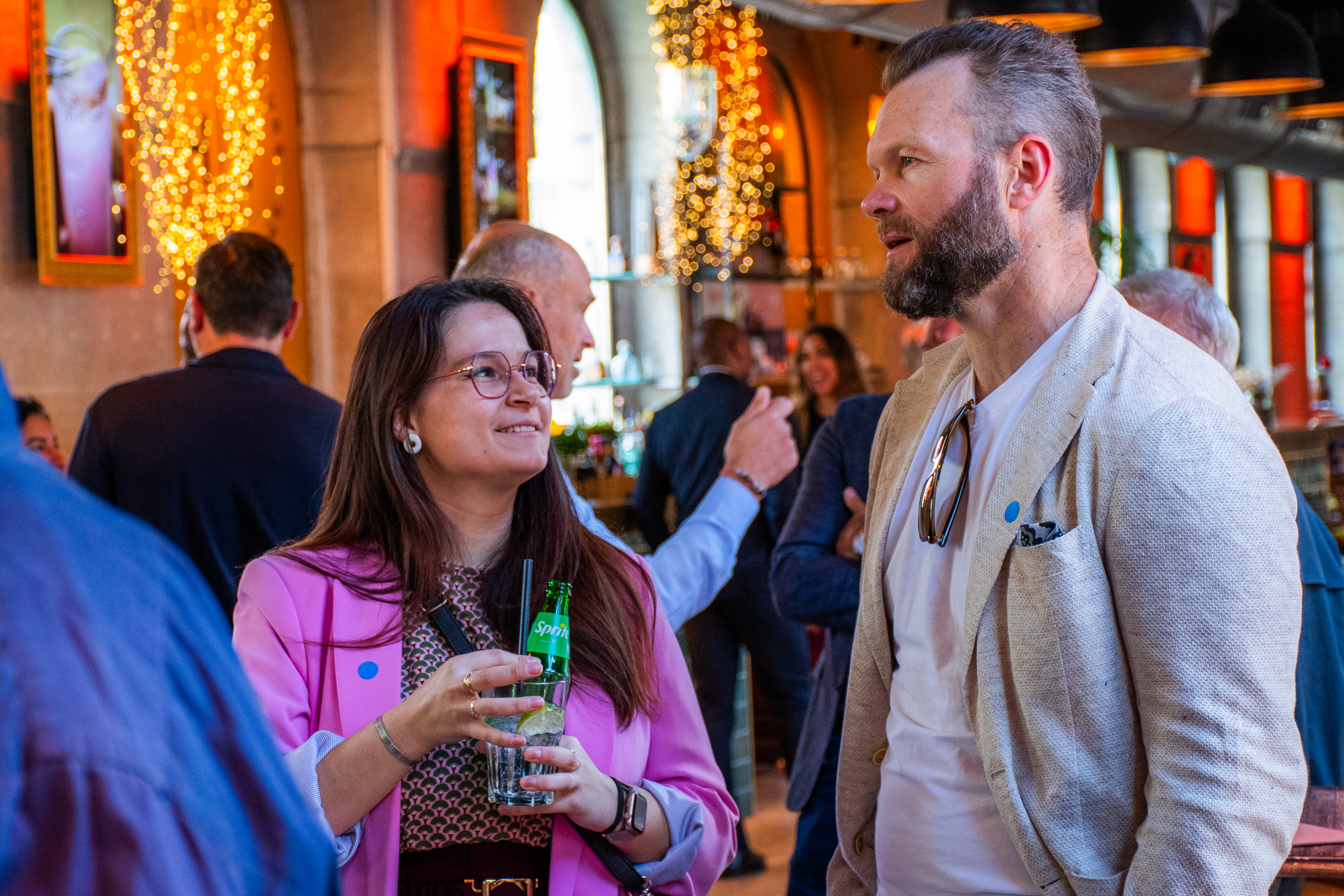 Two guests in conversation at the Switech networking event with warm ambient lighting