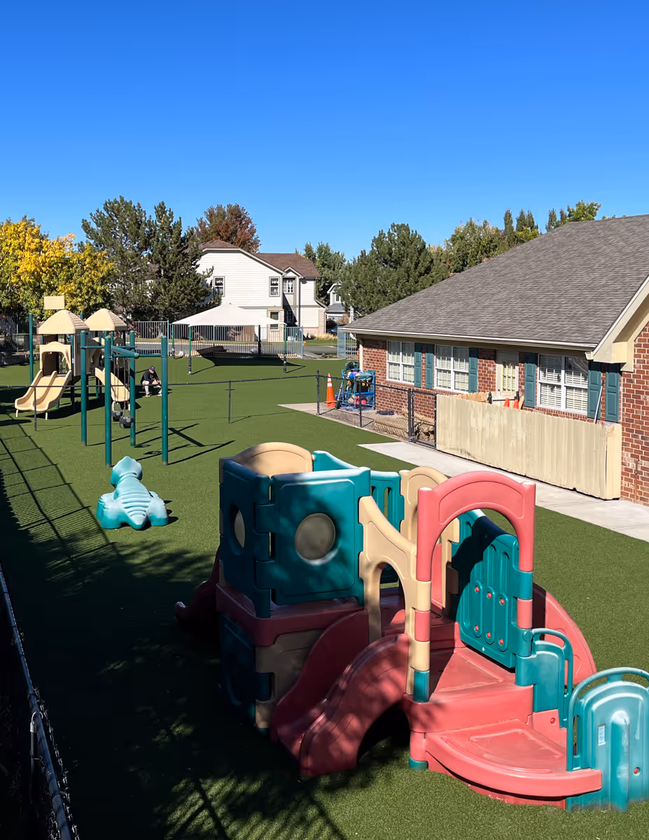 A modern house with a large backyard featuring an artificial putting green and golf hole.