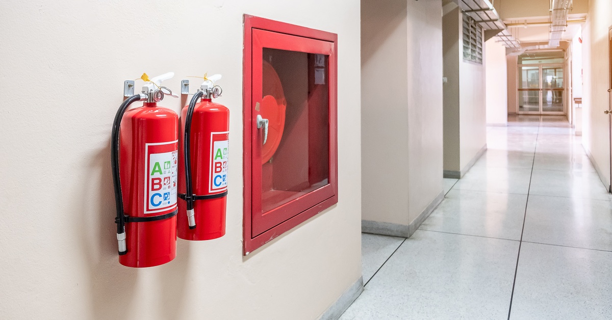 Two fire extinguishers mounted right next to each other. 