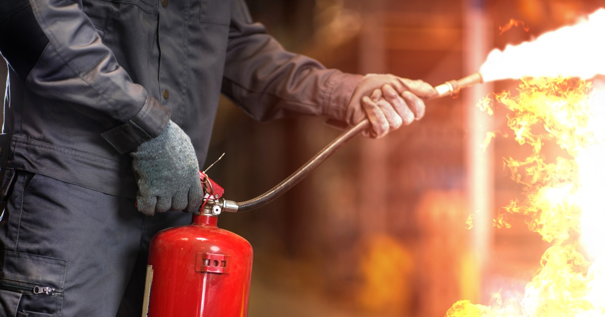 A person using a fire extinguisher to put out a fire. 