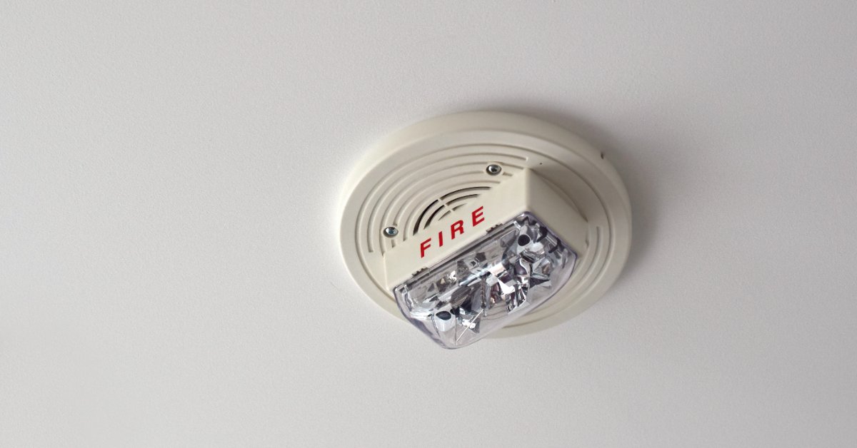 Close-up of a white ceiling-mounted fire alarm horn strobe notification device