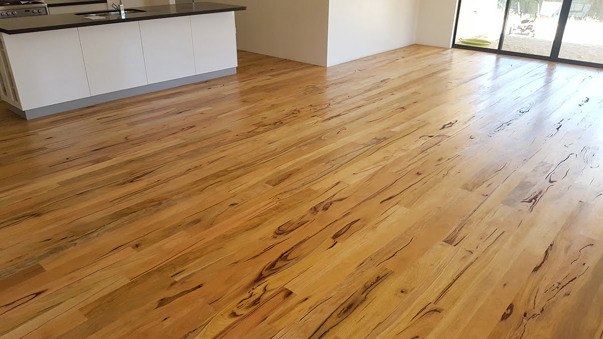 Natural finish on wide wood planks in an open kitchen by Brazil Floors