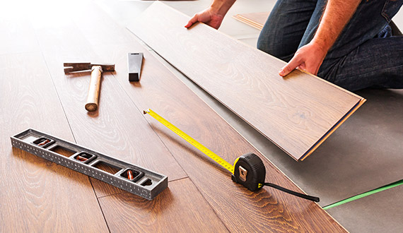 Vinyl plank install with a level and tape measure, done by Brazil Floors