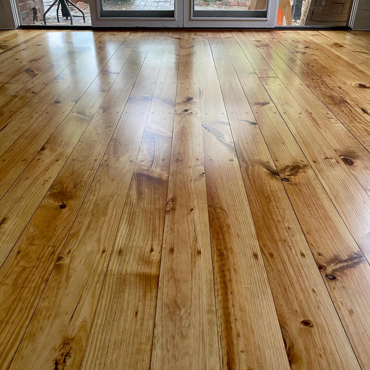 Wide pine boards restored with a warm clear coat by Brazil Floors