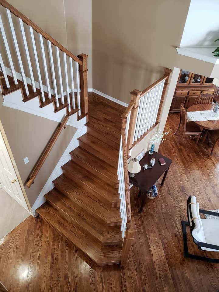 Repaired stair treads and handrail over a finished wood floor by Brazil Floors