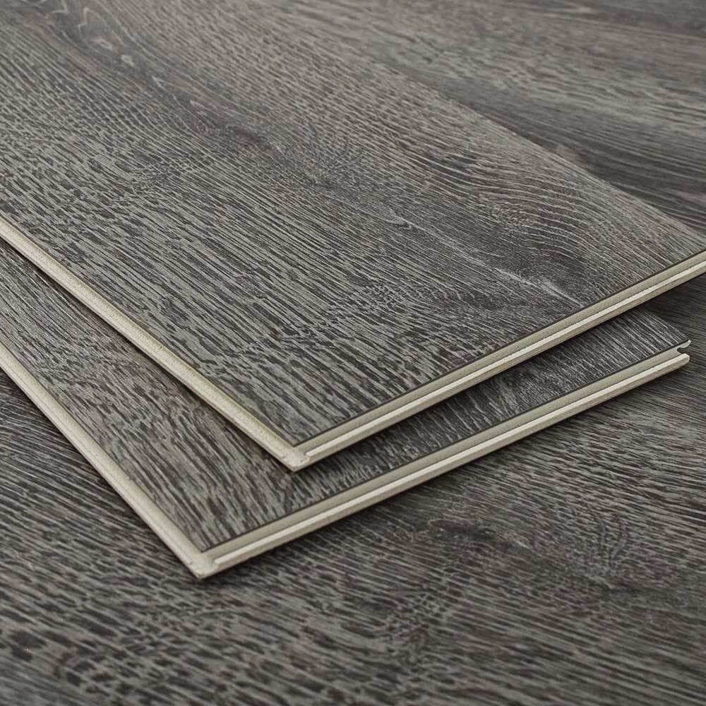 Gray wood look vinyl plank samples stacked on a floor, from Brazil Floors