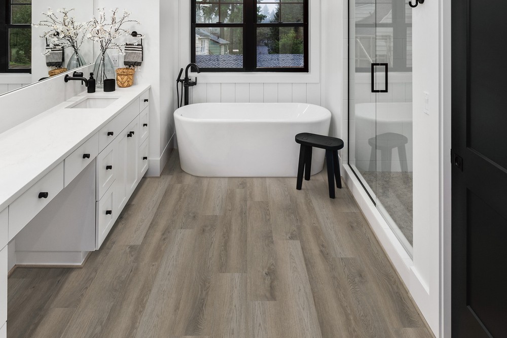 Elliptical Oak COREtec Pro 7 inch LVP in a bathroom with a freestanding tub by Brazil Floors