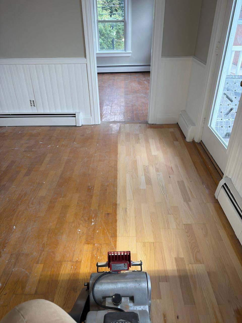Drum sander removing the old finish from a hardwood floor in Foster, RI