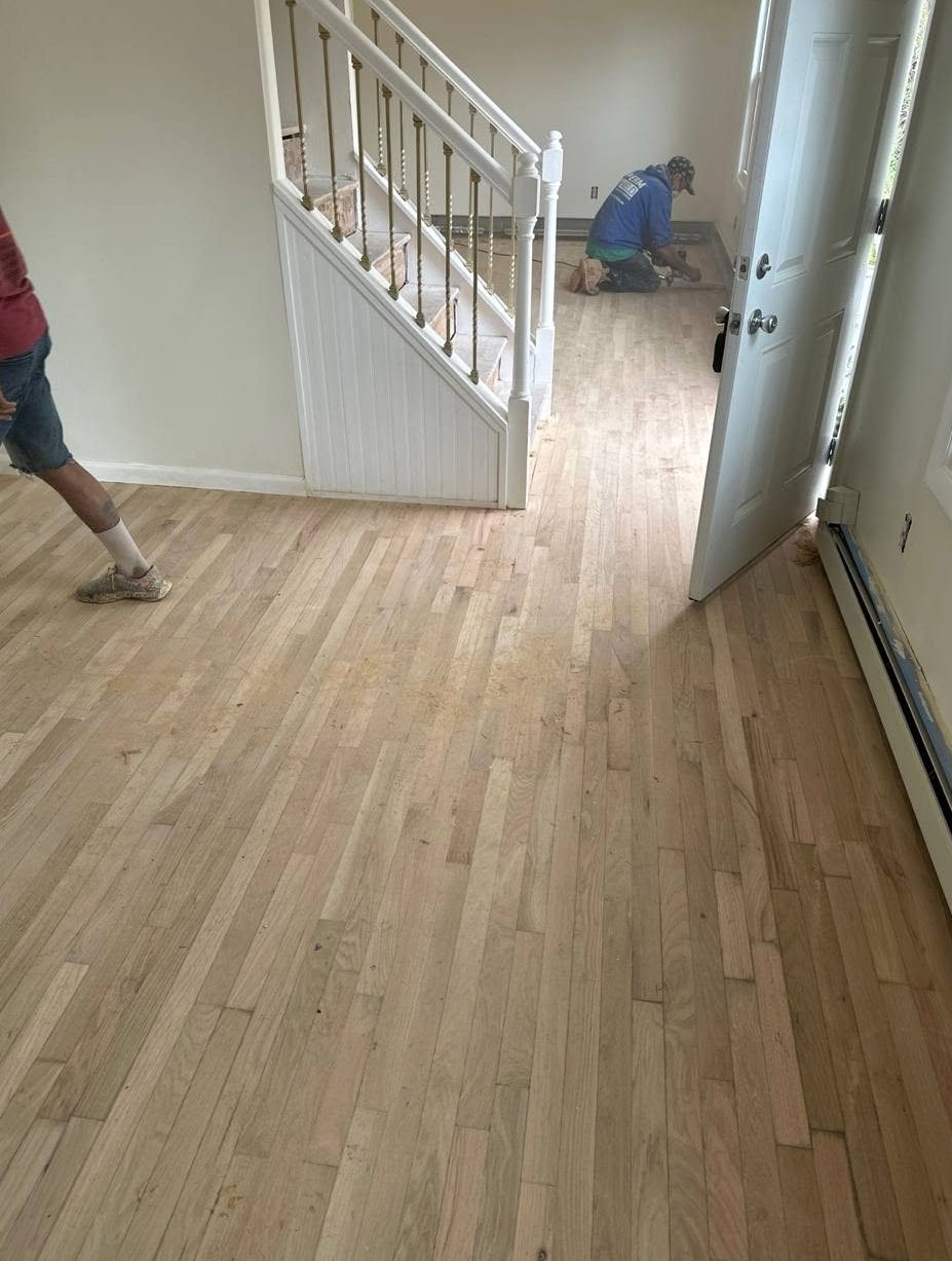 Installer setting new hardwood boards by the stairs in an Exeter home, Brazil Floors