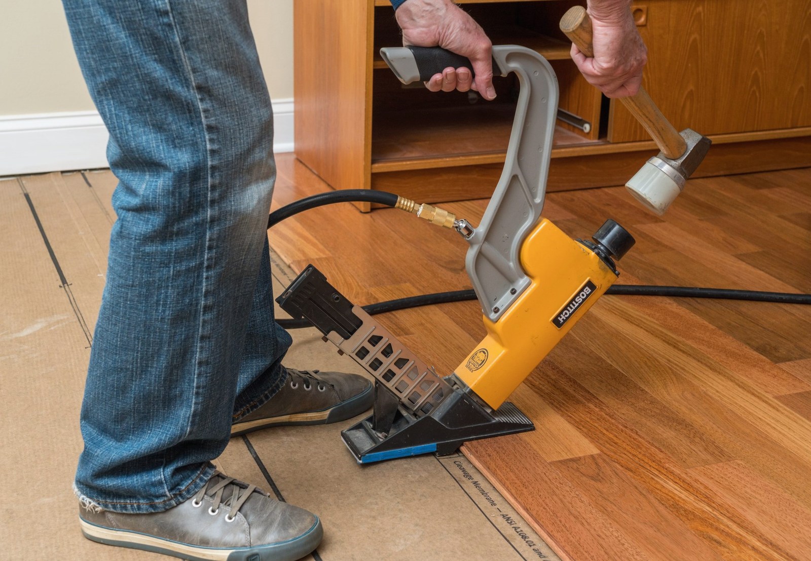 Close view of an installer using a flooring nailer in Warren, Brazil Floors