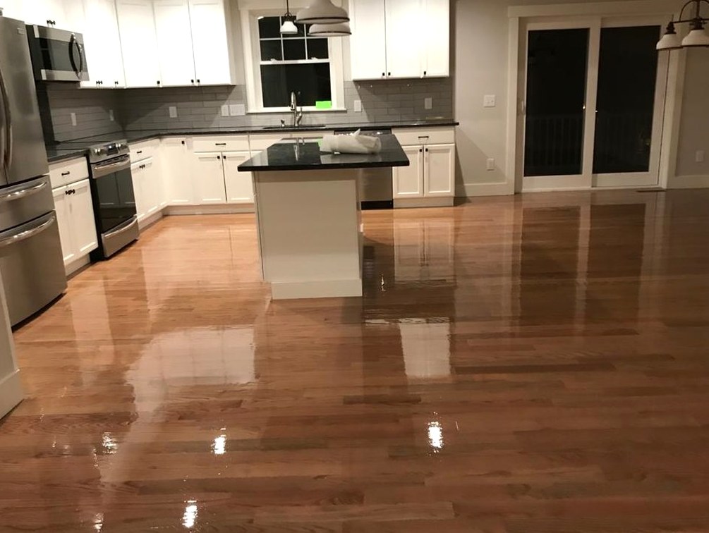 Sanded and glossy kitchen hardwood past the island counter inside a Jamestown home, Brazil Floors