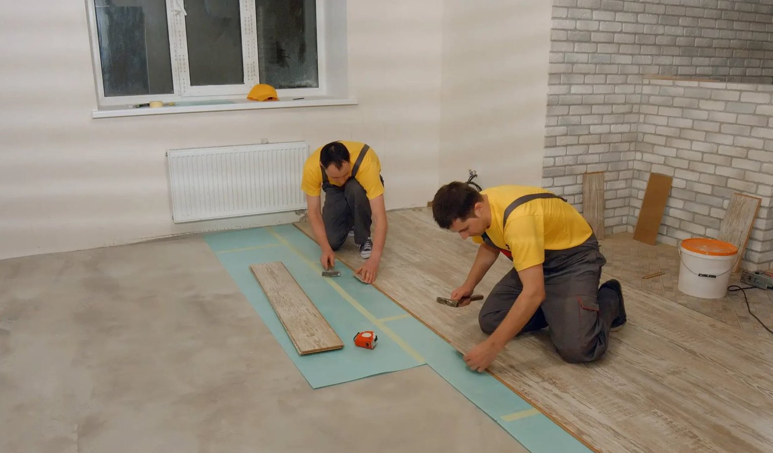 Installers fitting vinyl rows in an Arnold Mills home, Brazil Floors