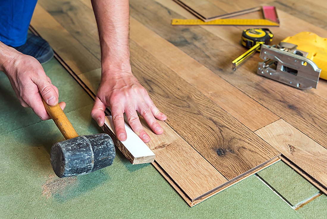 Installer tapping vinyl into a row over underlayment off West Main Road, Brazil Floors