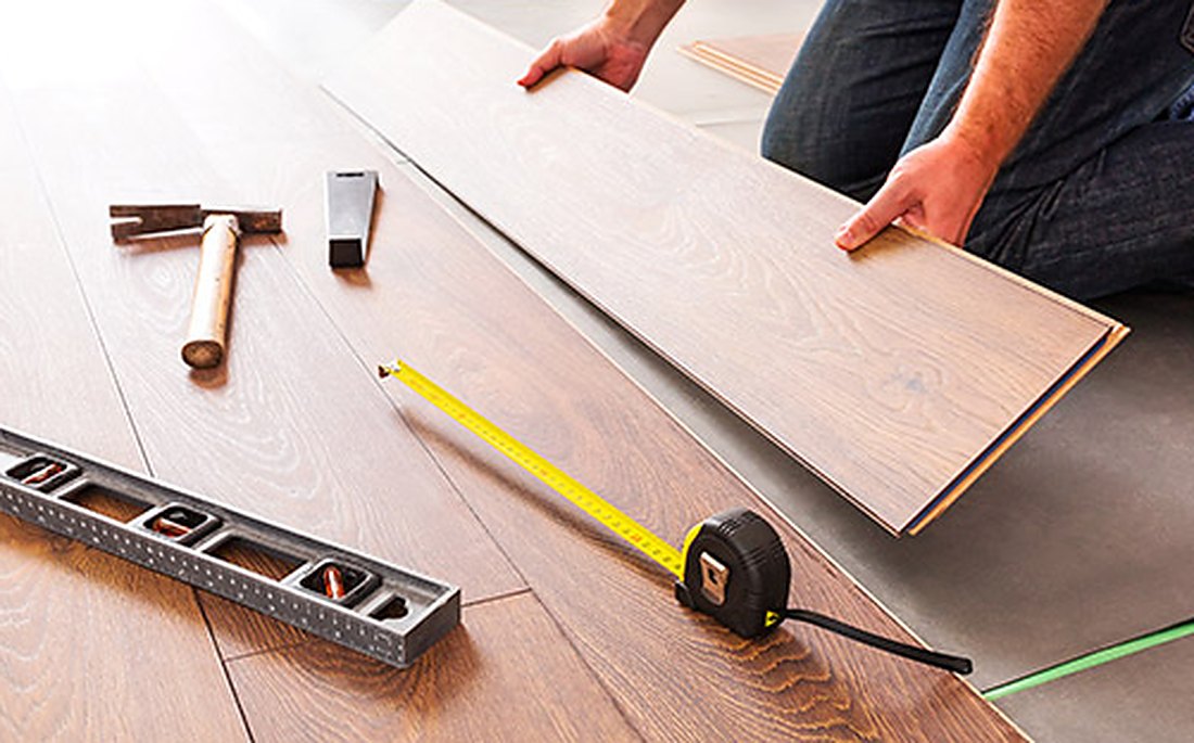 Level and tape measure on vinyl planks near Davisville, Brazil Floors