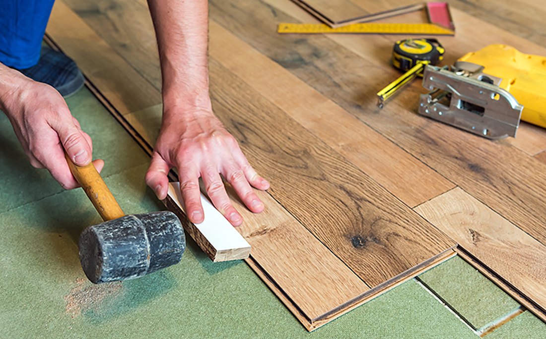 Installer setting a plank on green pad in Pawcatuck, Brazil Floors