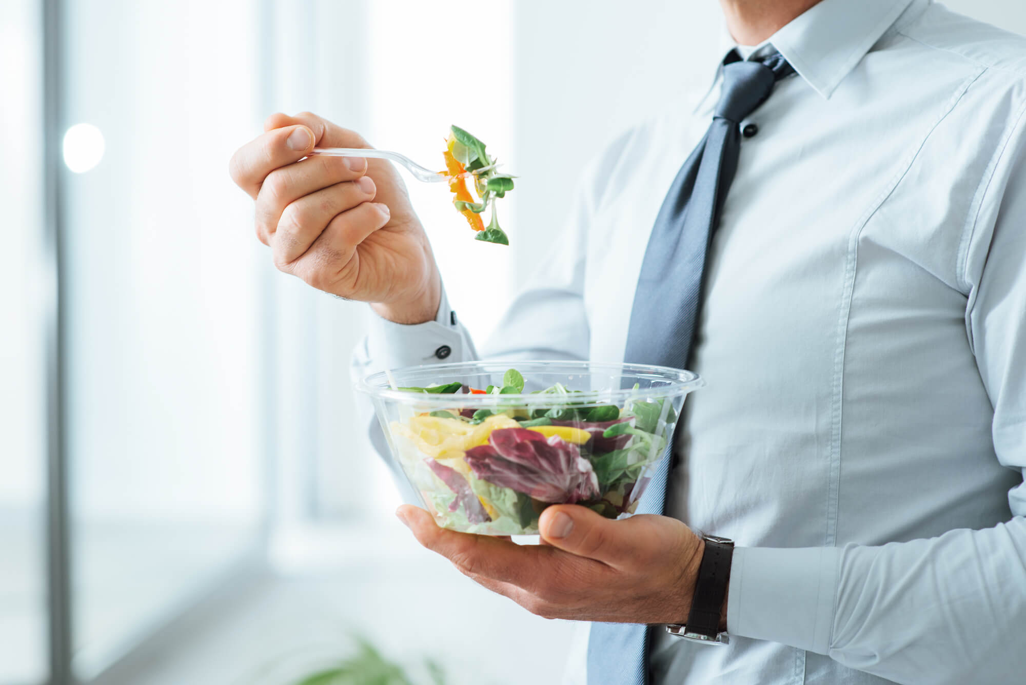 A businessman eating a salad