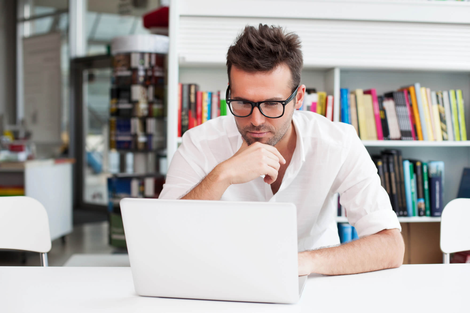 man intently looking at laptop to respond