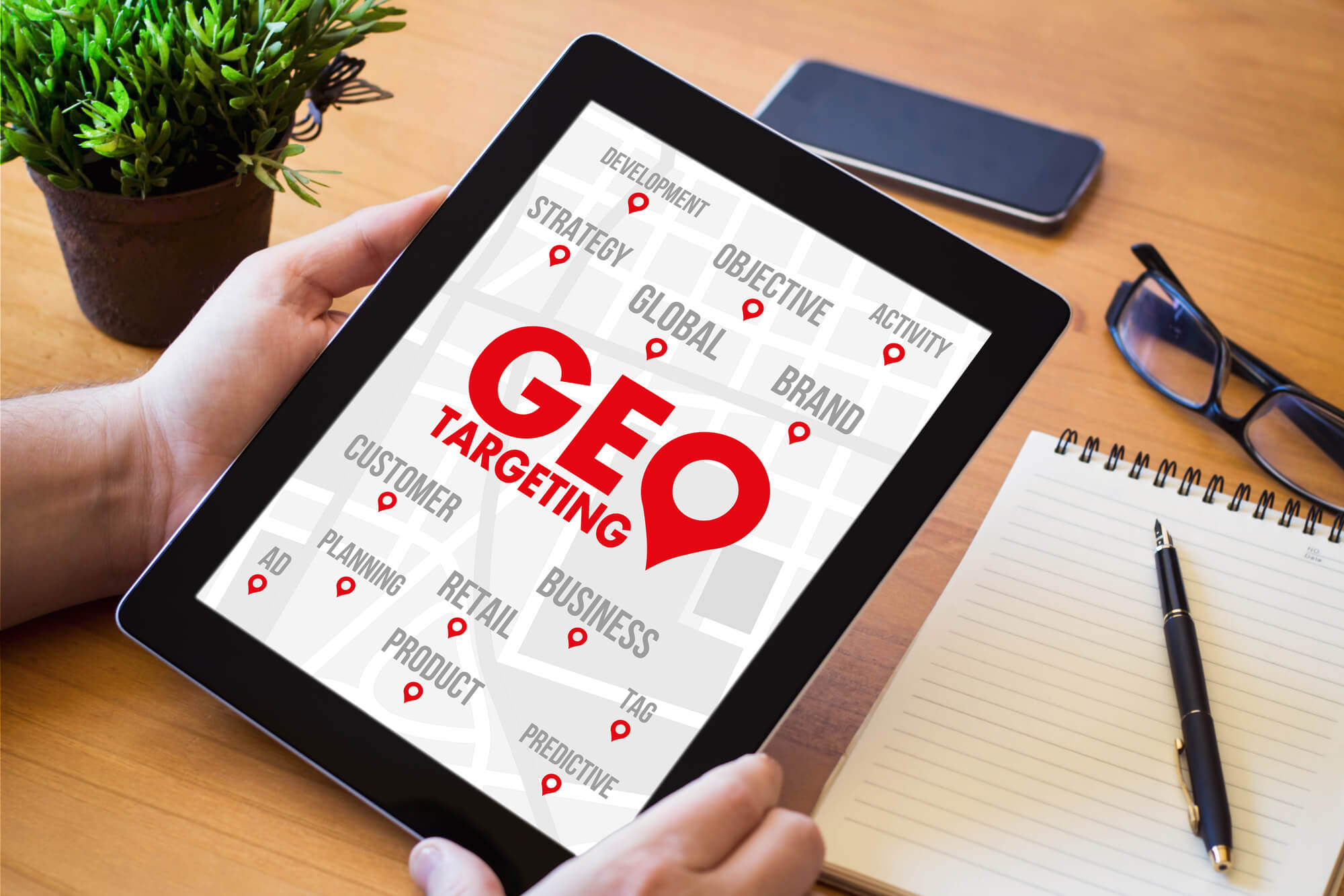 person holding tablet showing geotargeting on screen