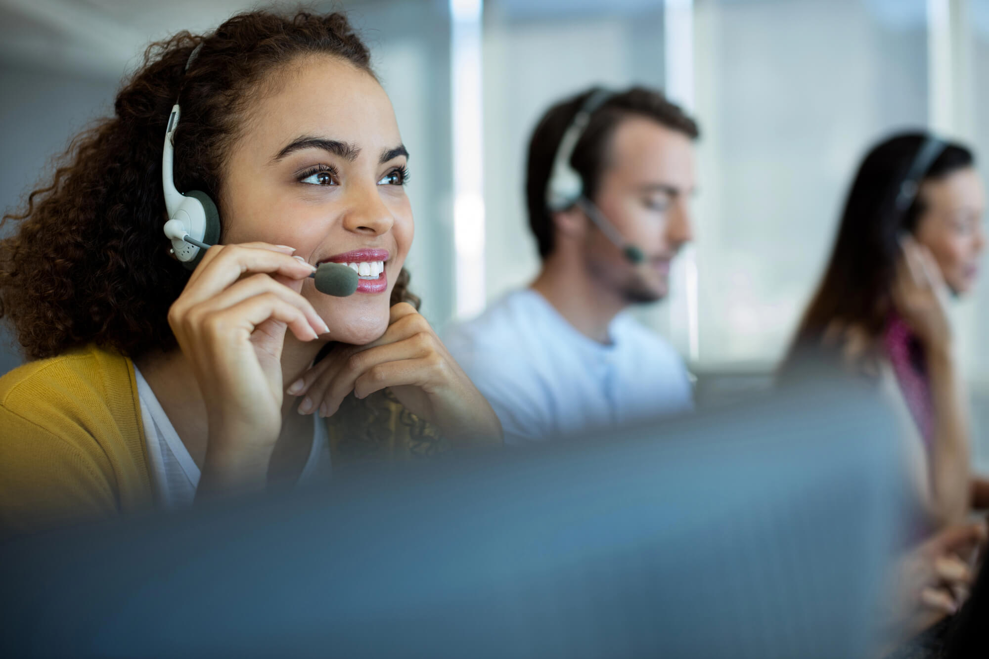 customer service agents talking with clients through headsets