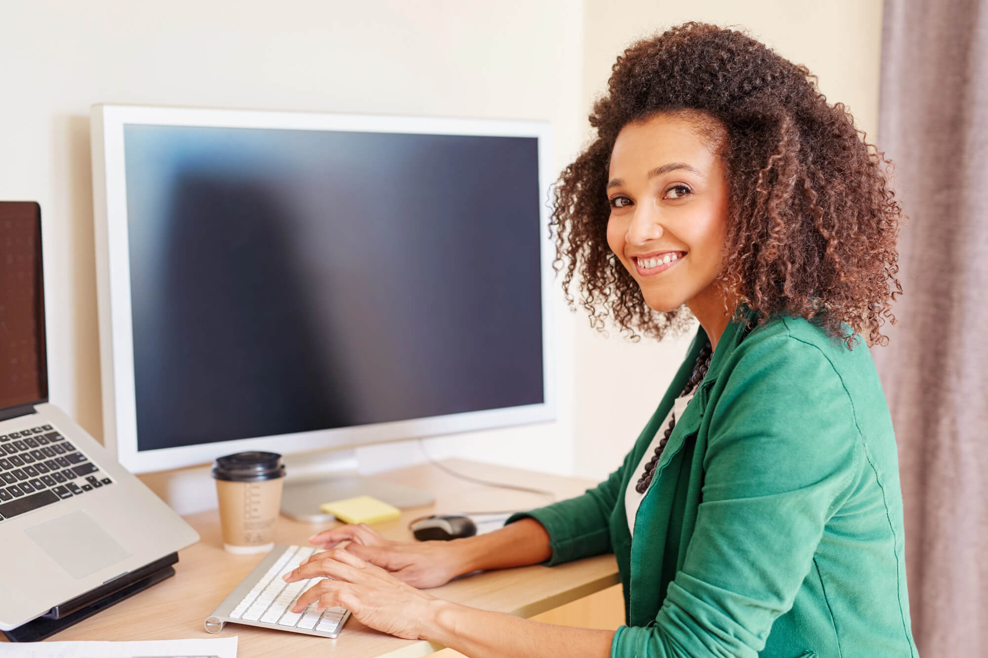 Digital marketer working on a campaign at her desk, looking confident and engaged