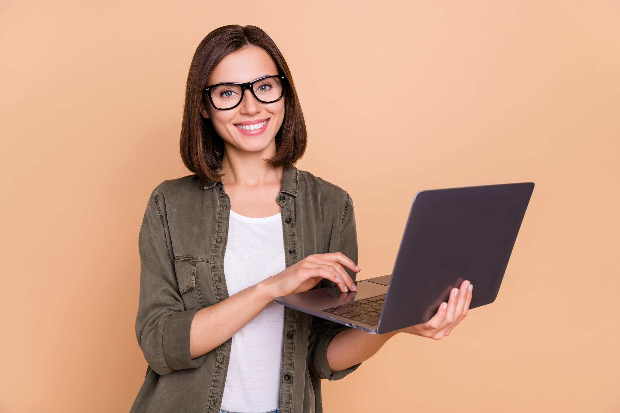 female digital marketer smiling while holding a laptop