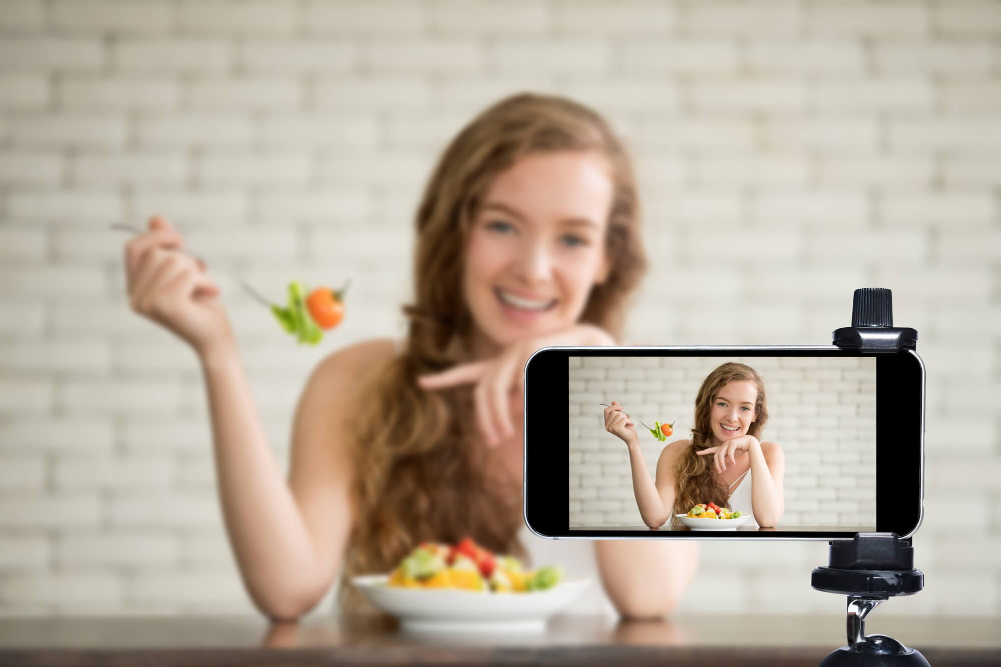 female influencer recording a video of herself eating for likes