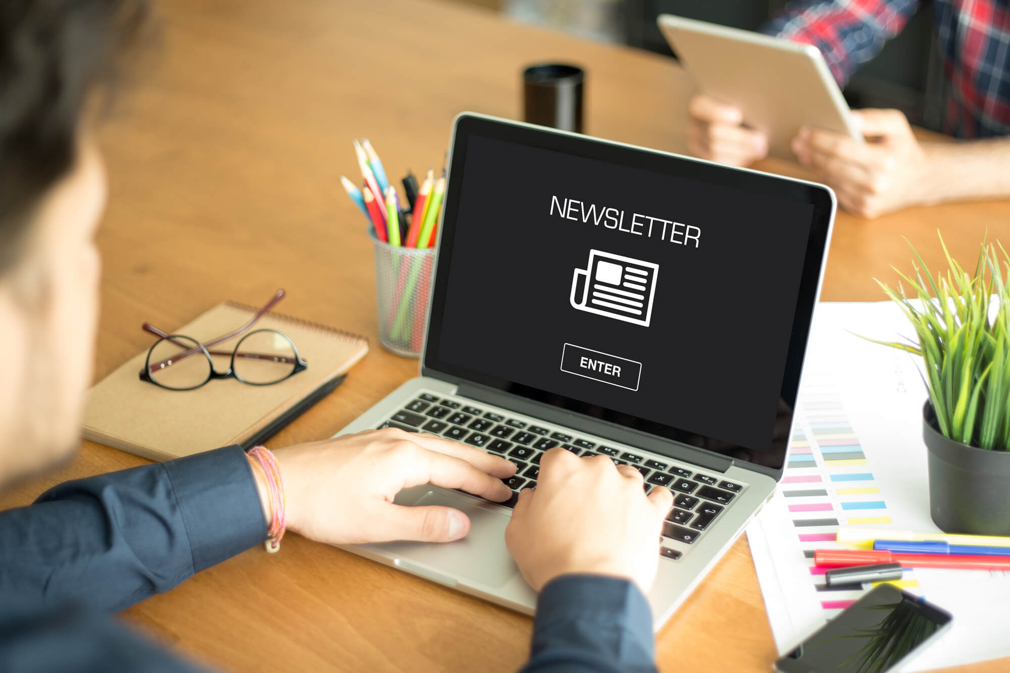 man working on newsletter on laptop