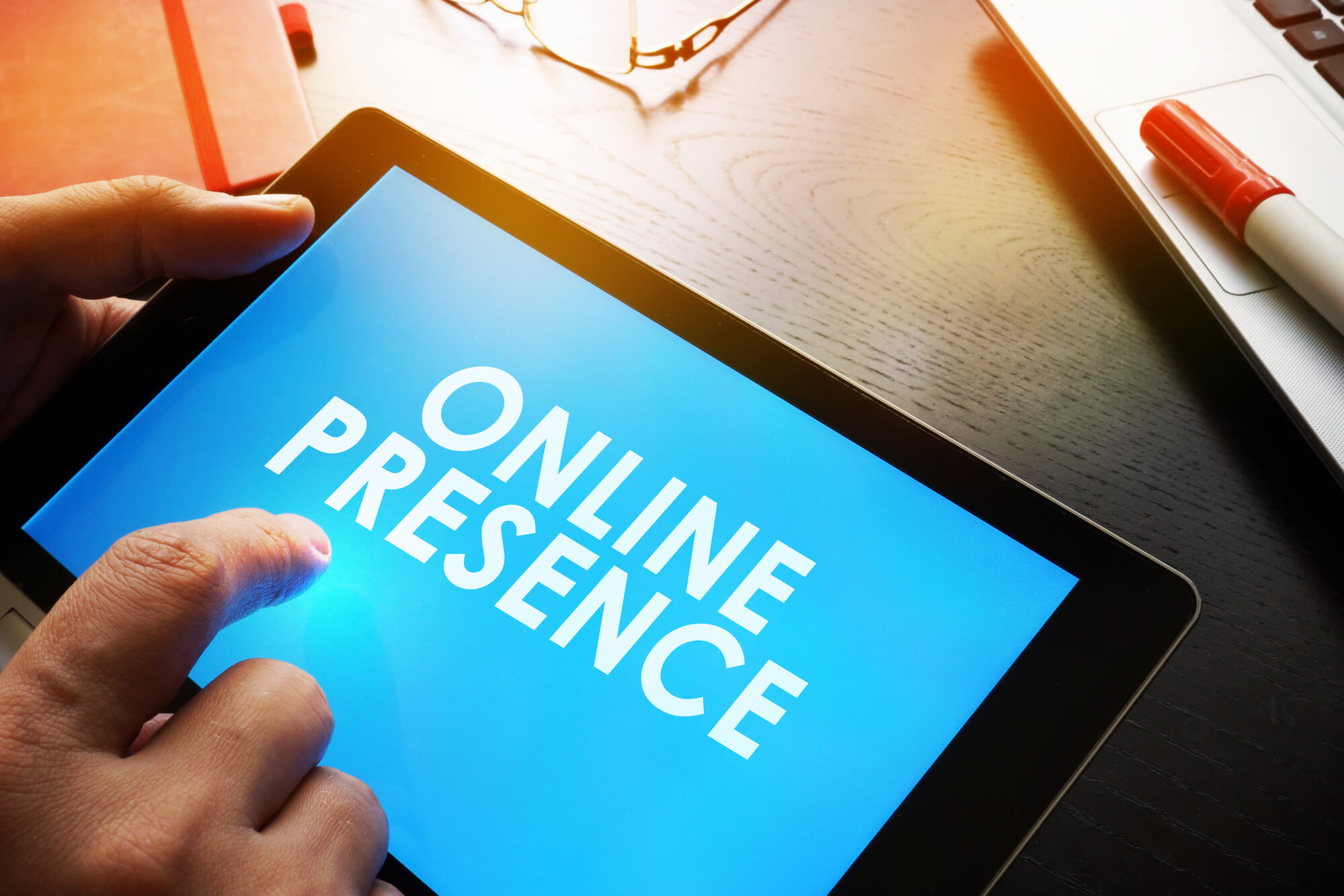 man holding tablet that says online presence on screen