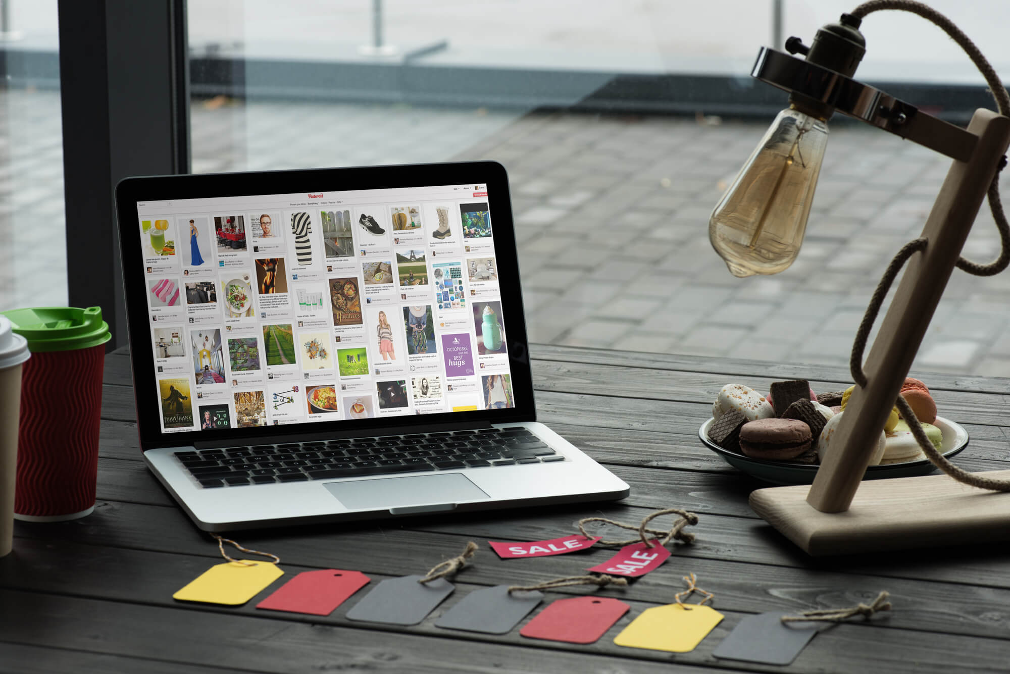 laptop showing pinterest website with sale tags near it