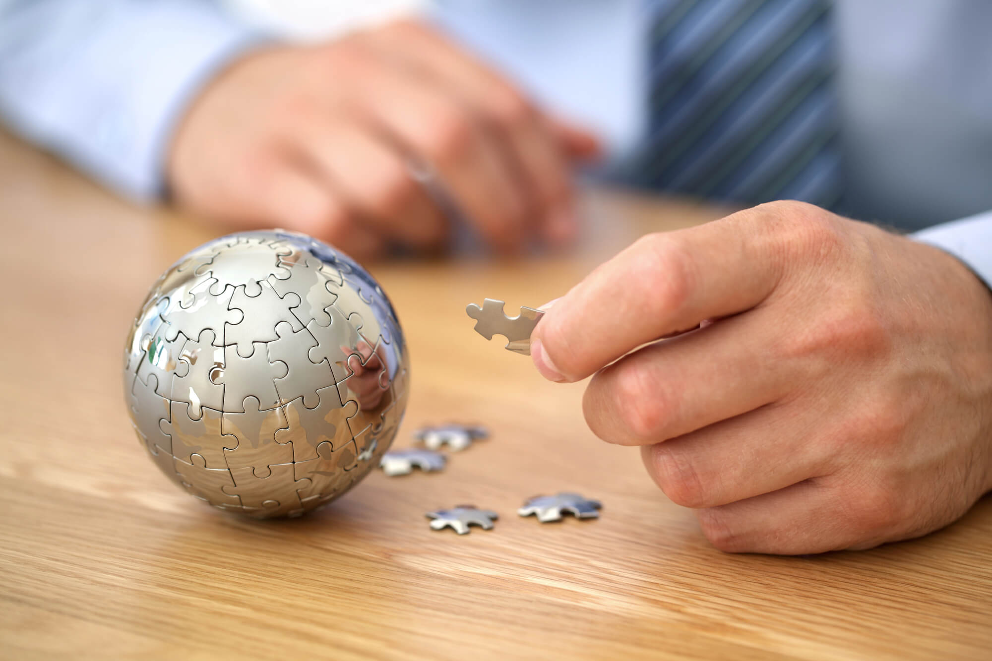 businessman piecing a puzzle of a globe