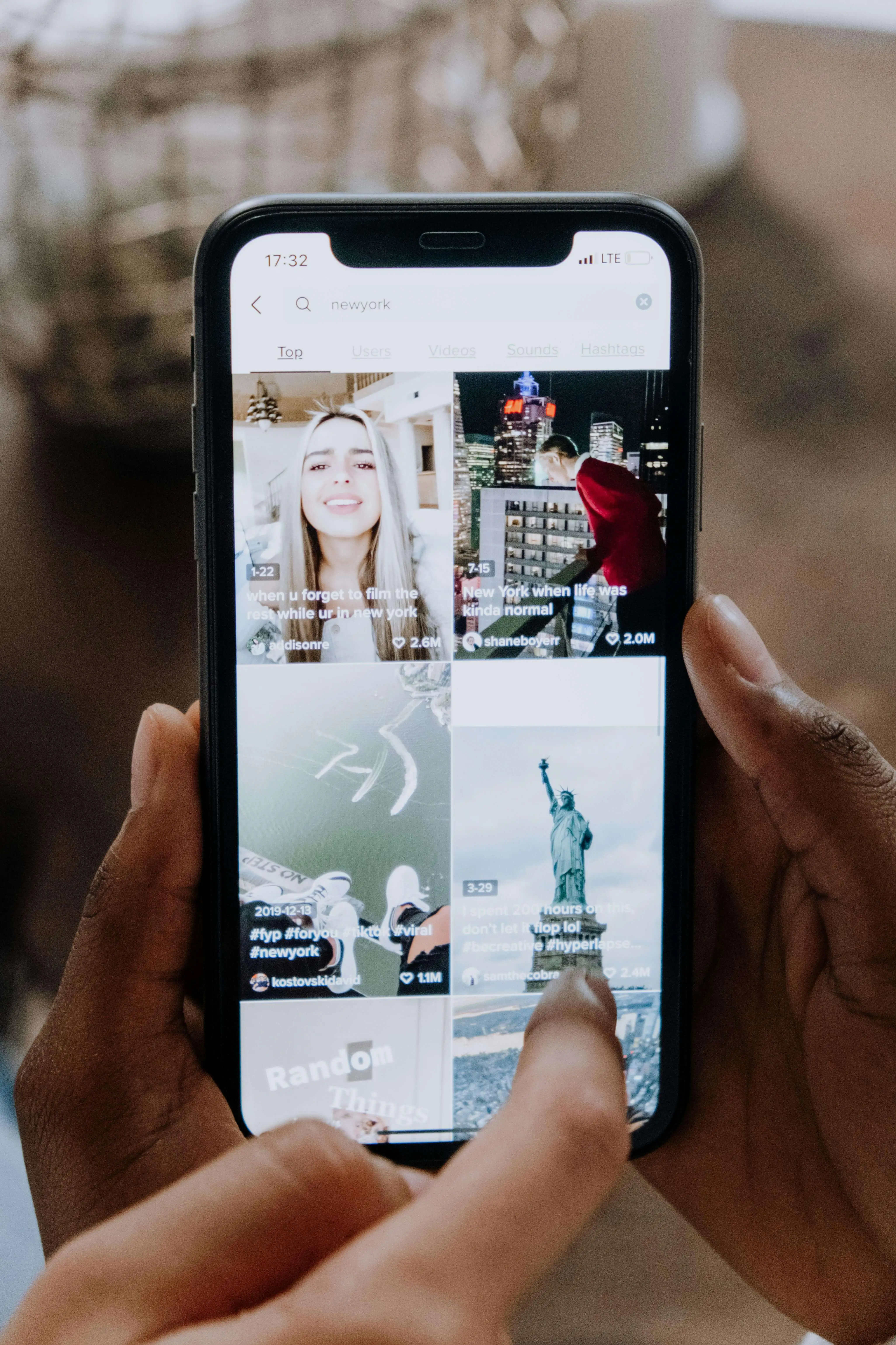 Person holding a phone on a TikTok explore page