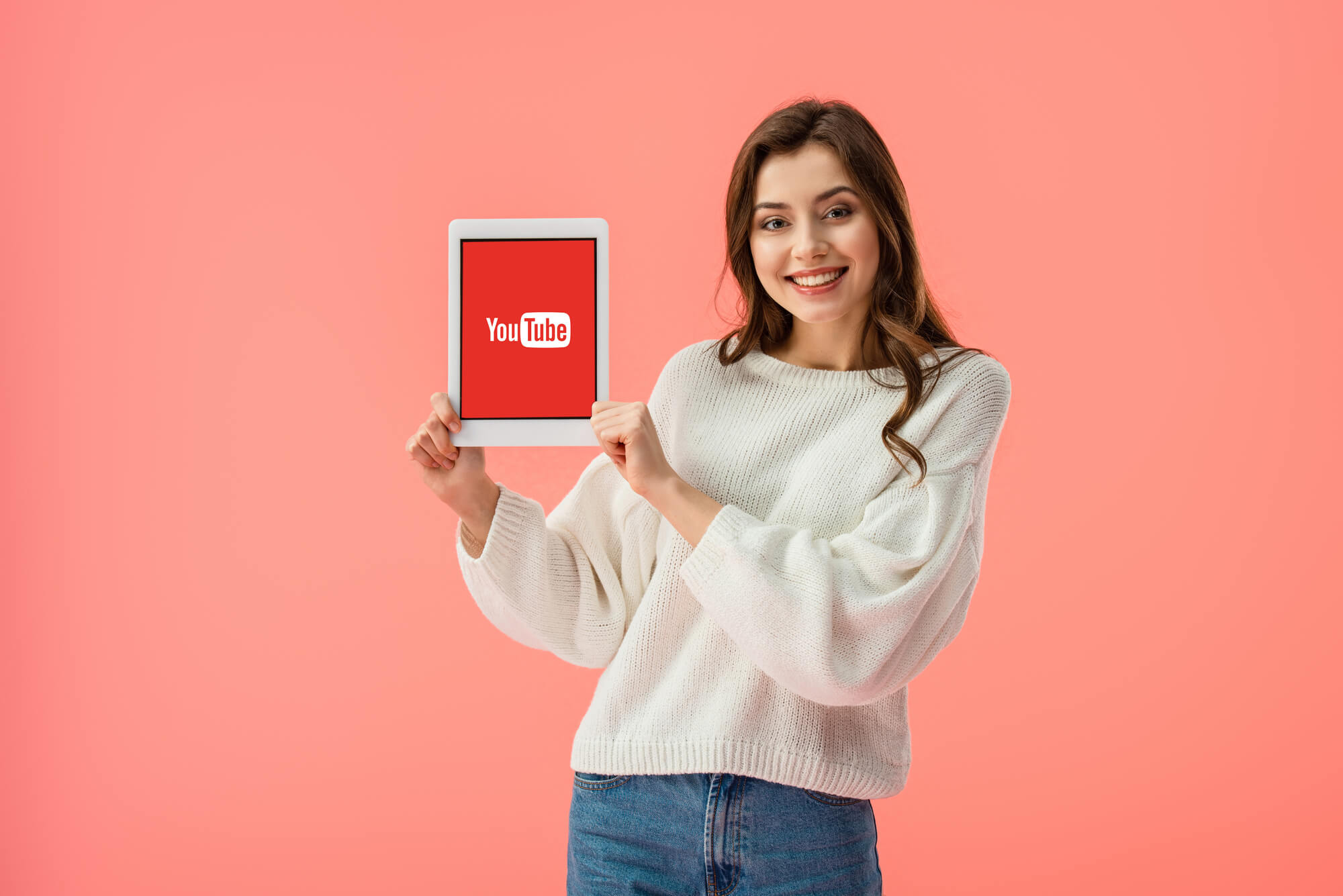 YouTuber smiling and holding ipad with YouTube logo.