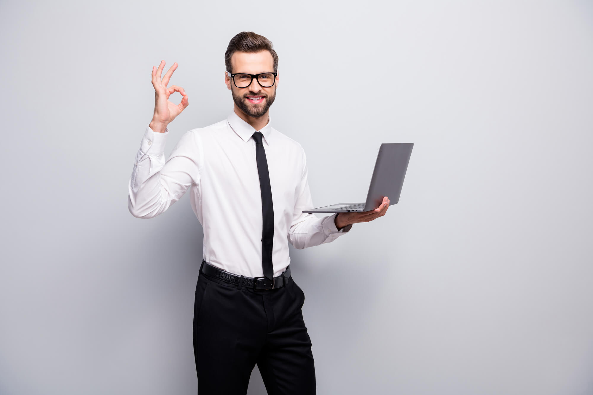 professional man holding laptop and showing ok sign
