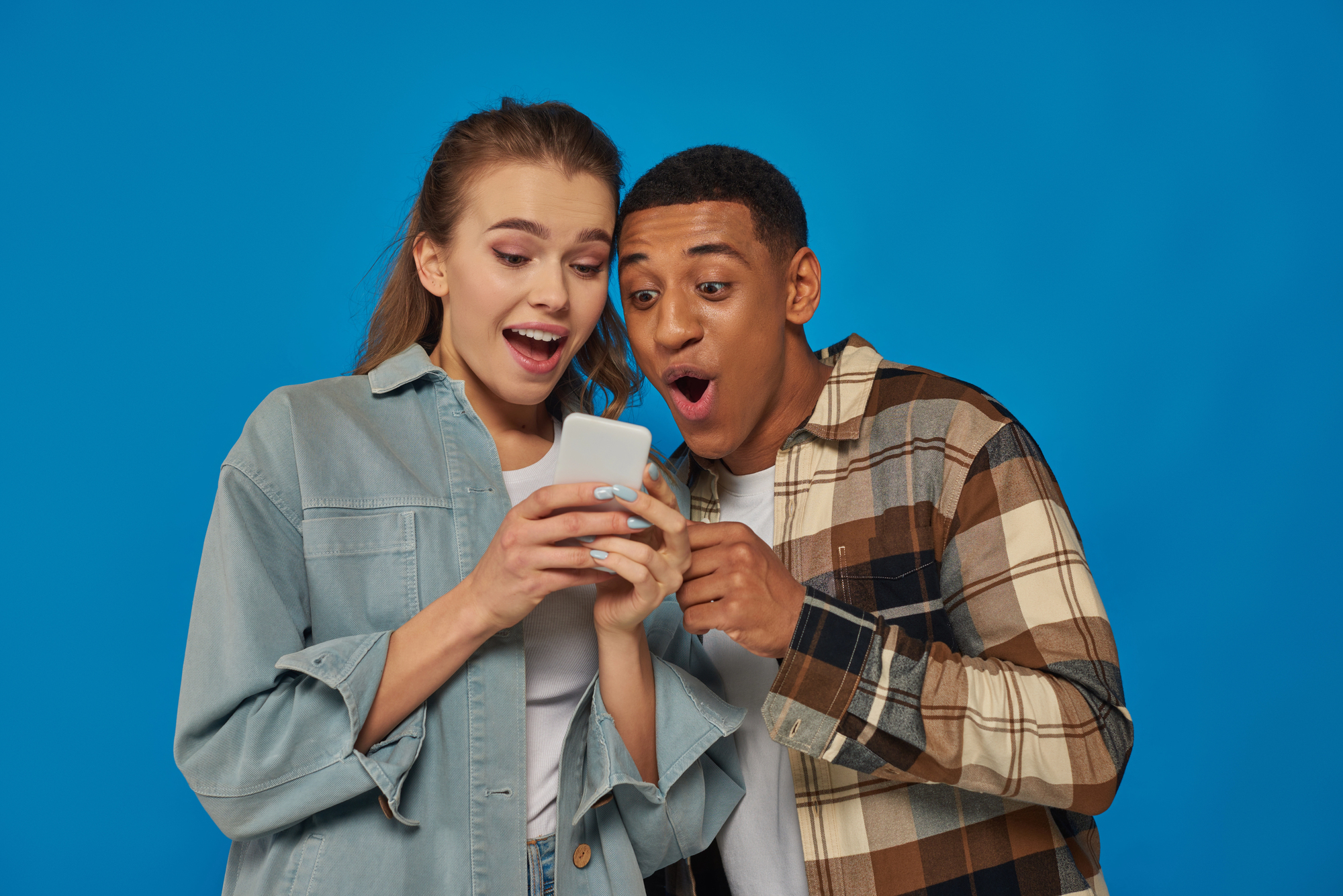 man and woman watching something on phone