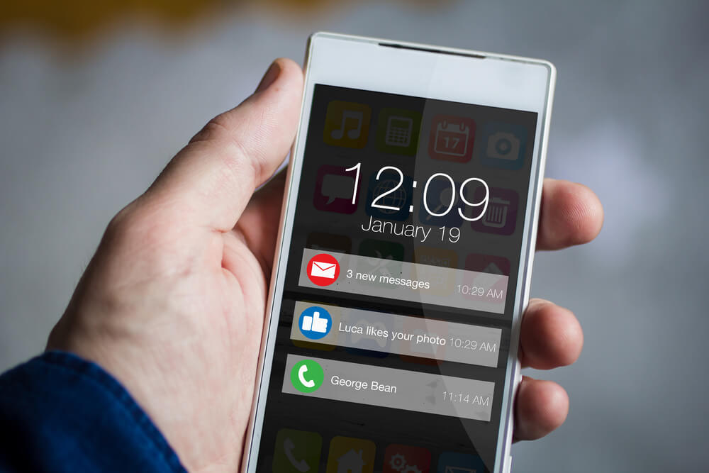 male hands holding smartphone with notifications on screen