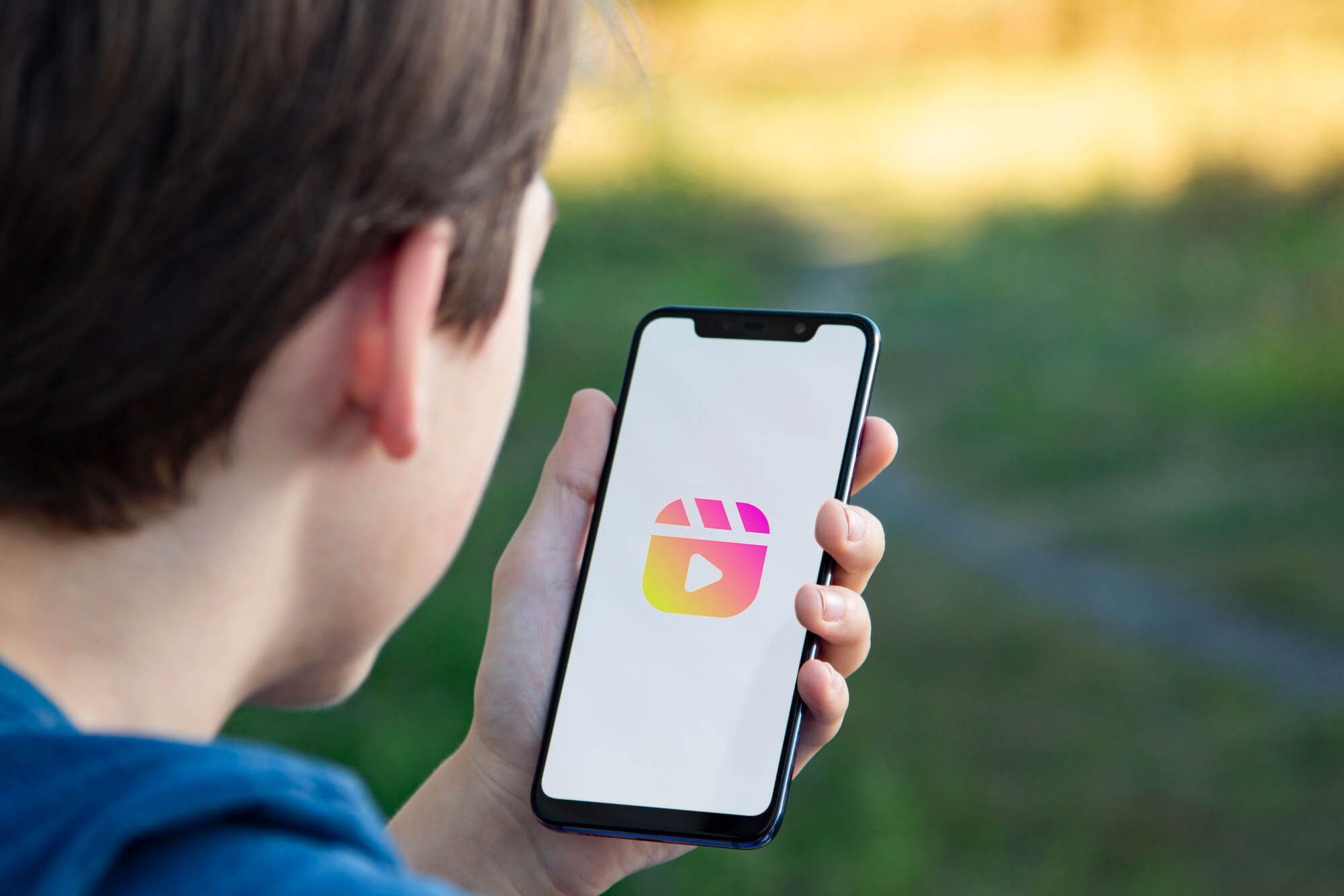 boy holding a phone with reels logo