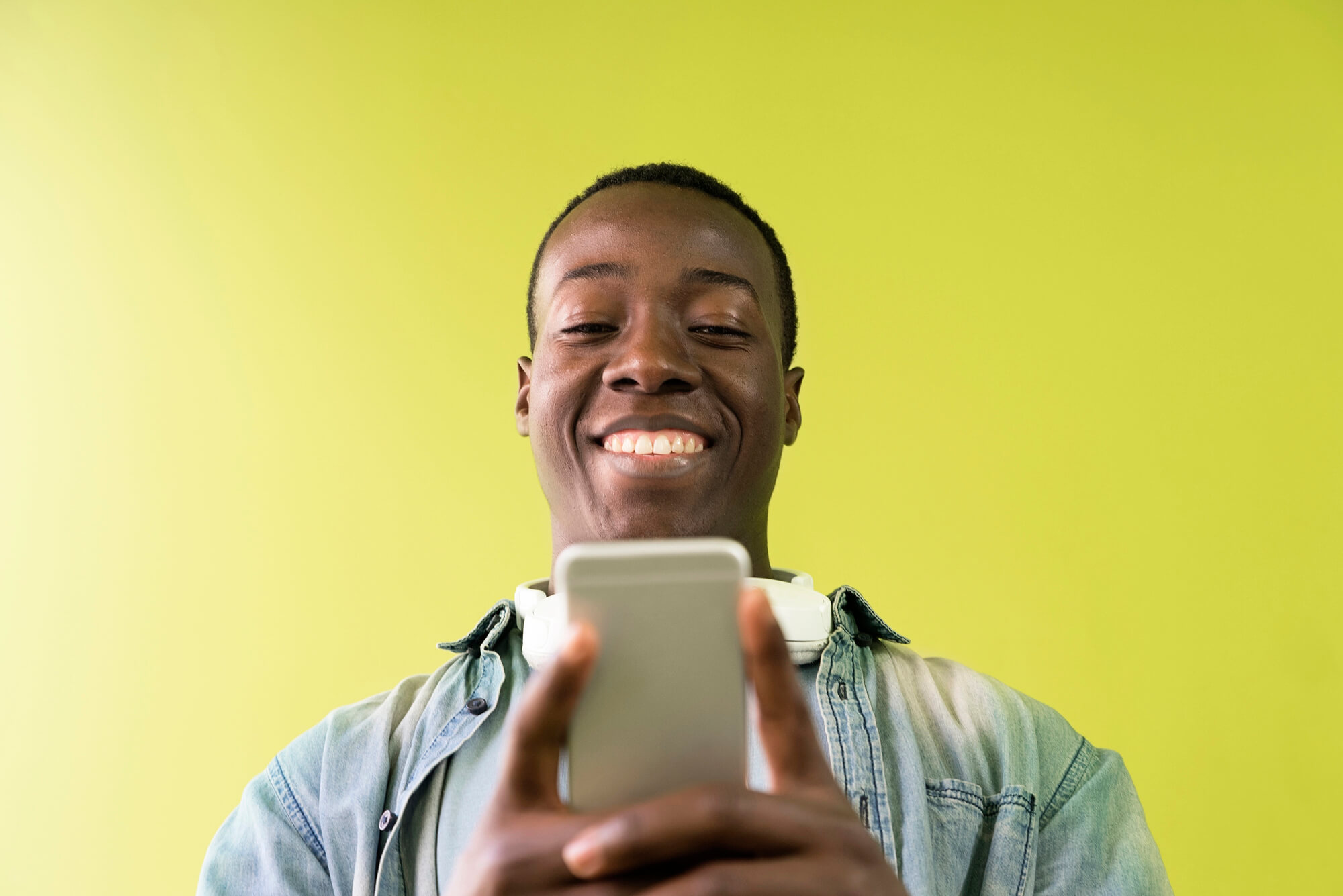 A man smiling as he scrolls through his phone