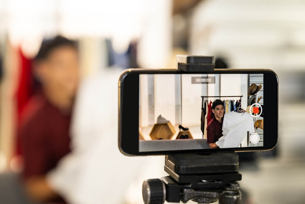 Business owner using phone to make video content to add to his web design in West Palm Beach.