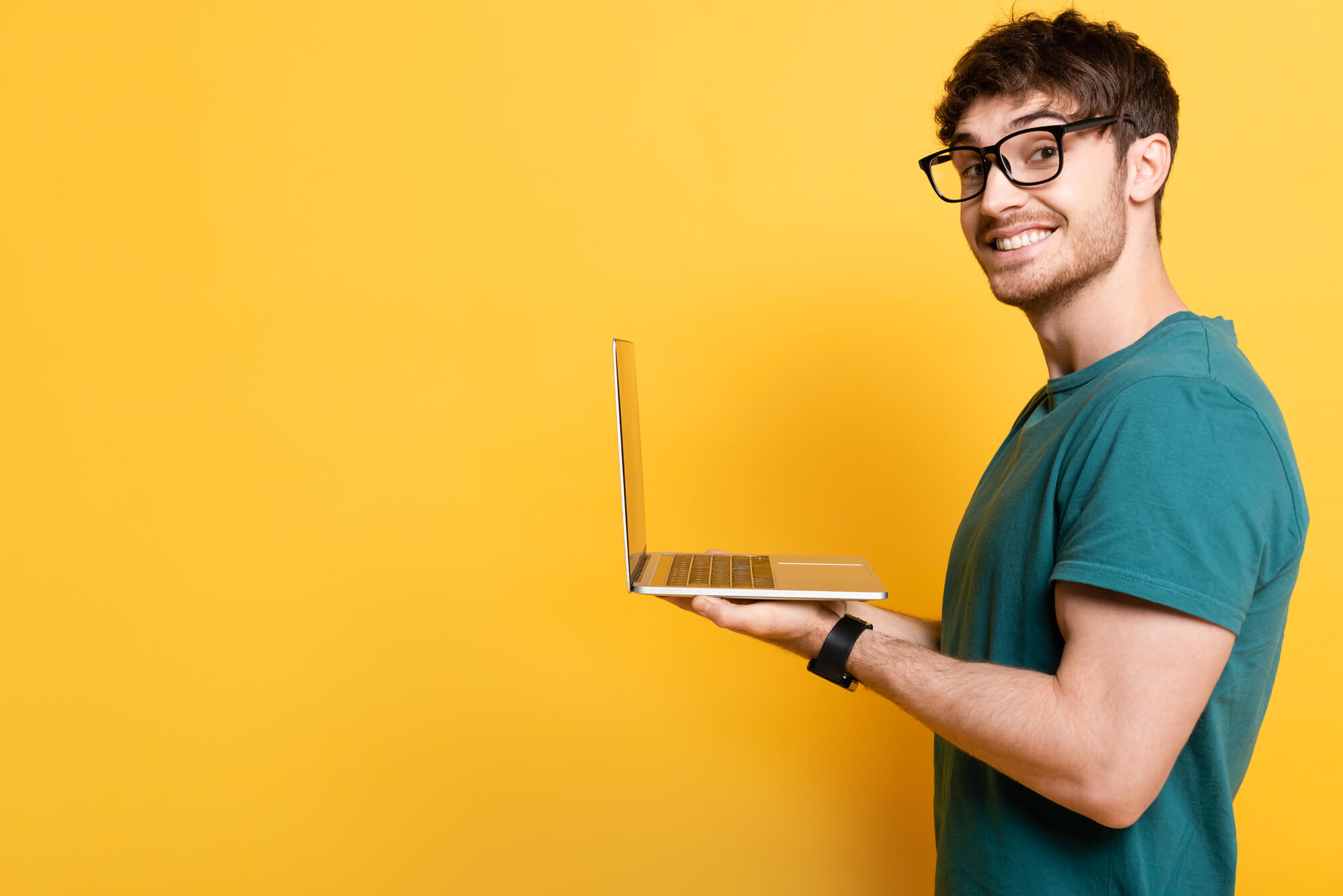 digital marketer holding laptop while smiling at the camera