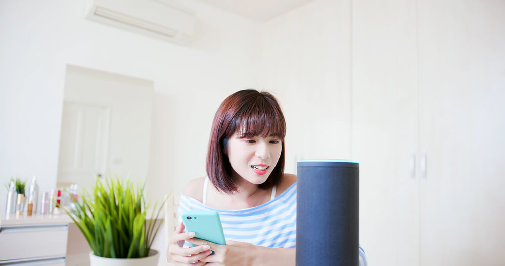 girl talking to a smart speaker looking for a local restaurant