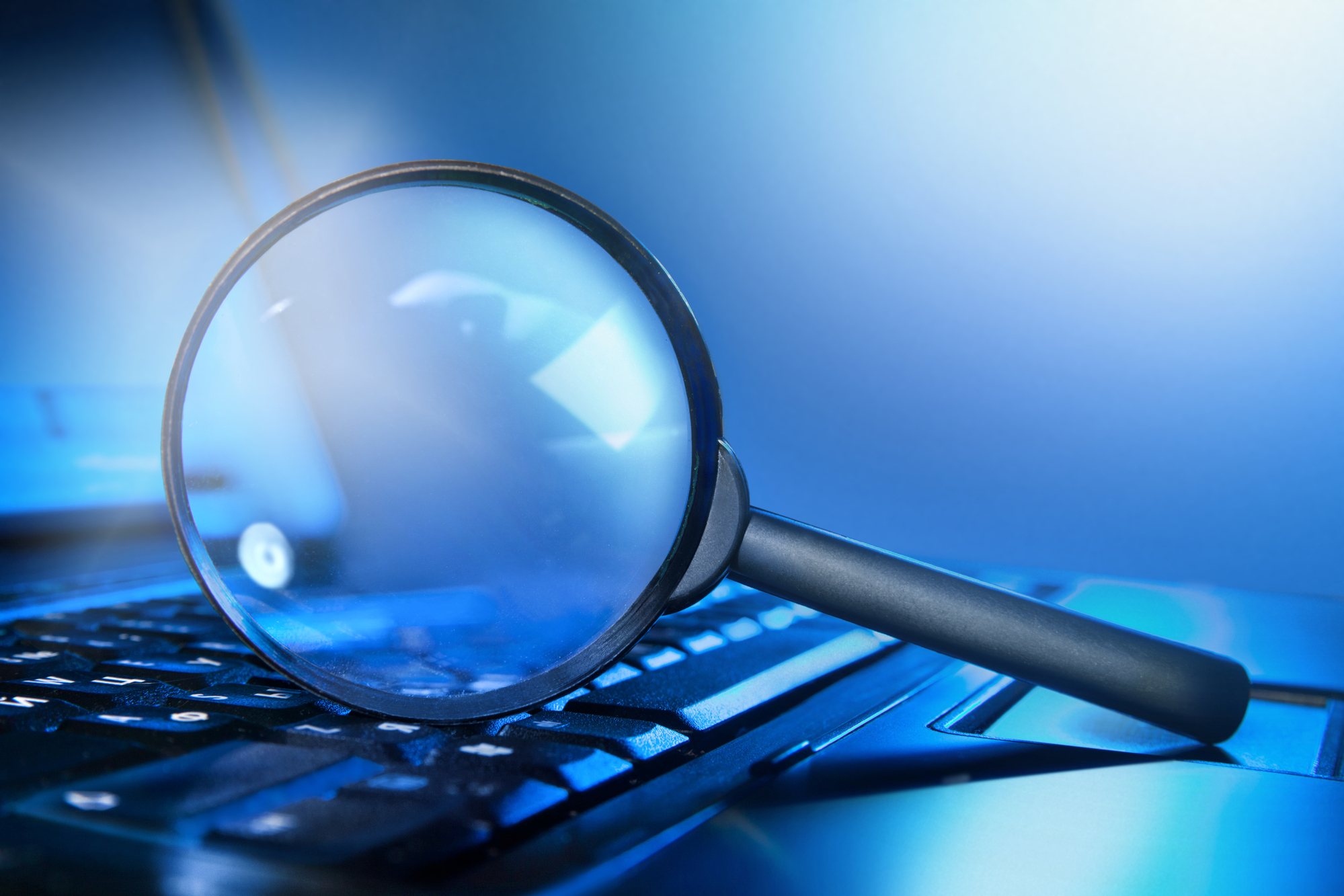 magnifying glass on top of a laptop