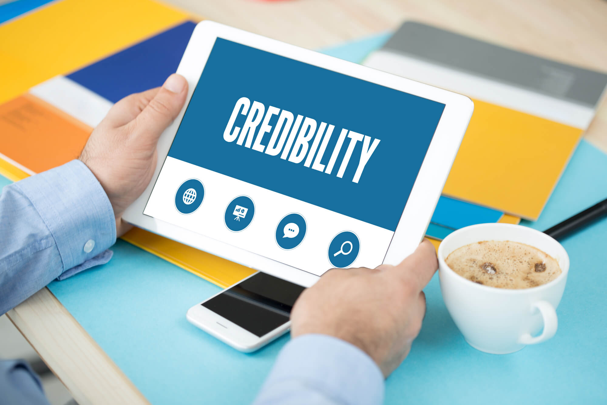 professional holding tablet showing credibility on screen