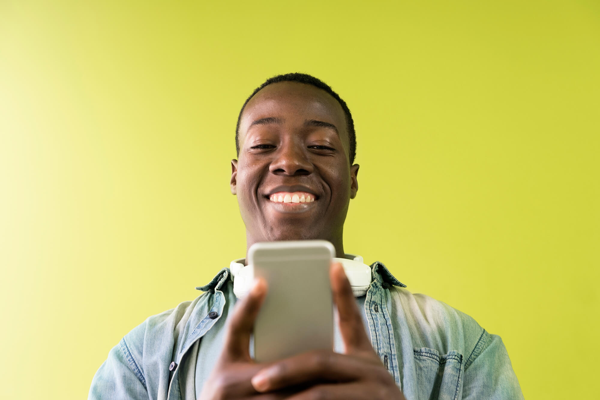 black man happily concentrating on his phone