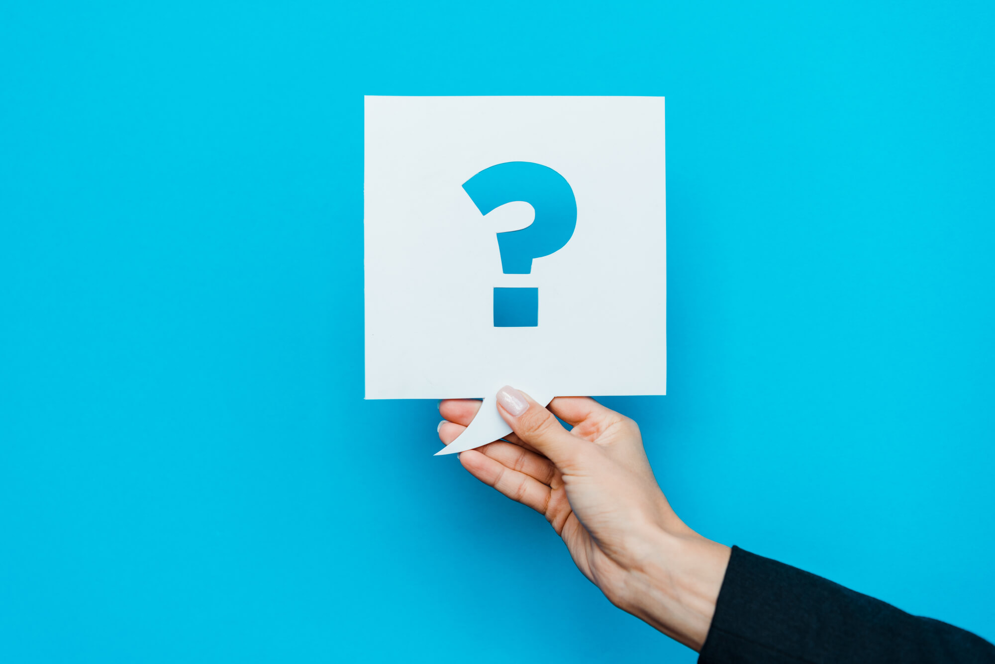 hand holding a speech bubble with question mark