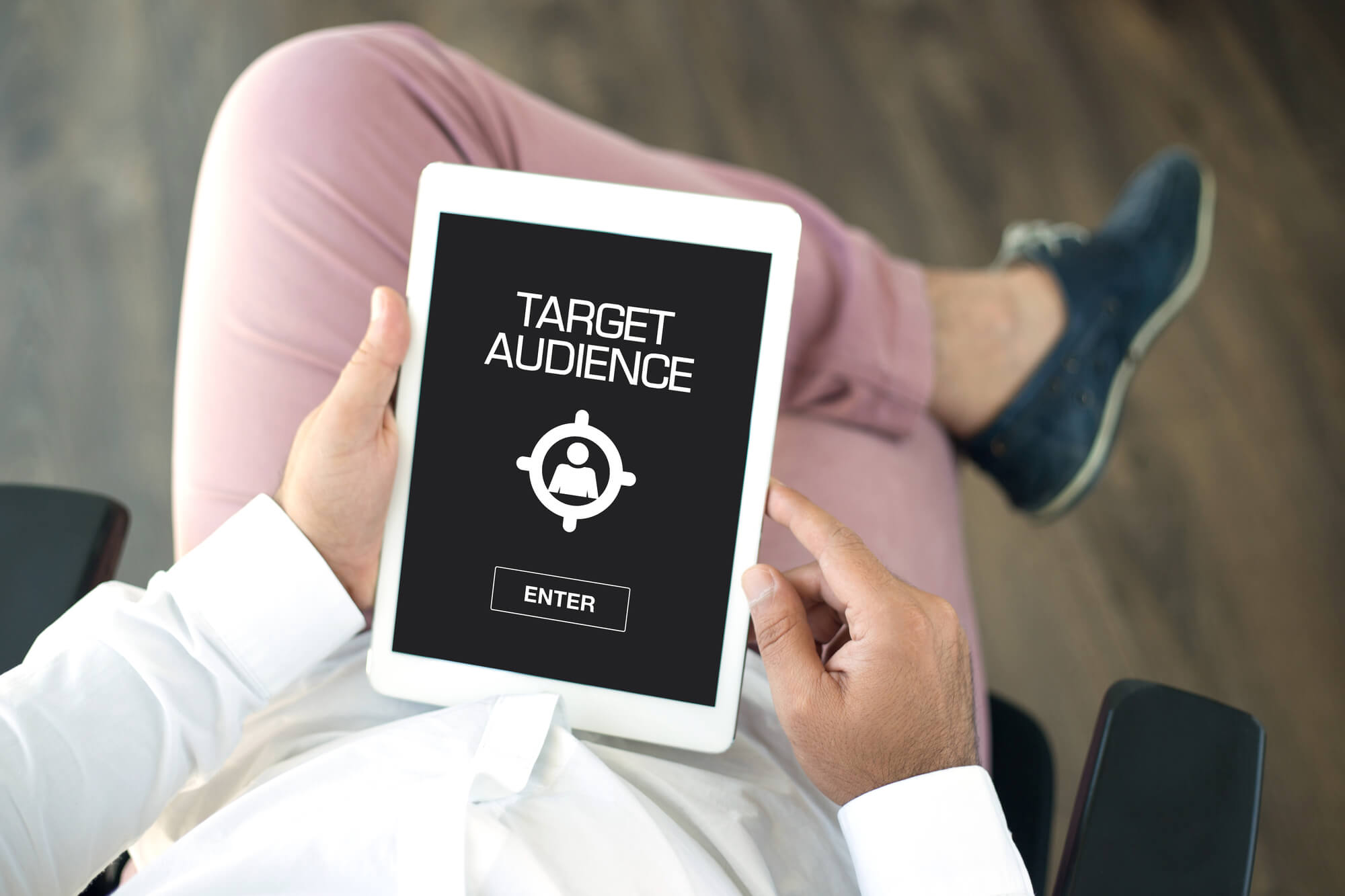man holding and looking at tablet that says target audience