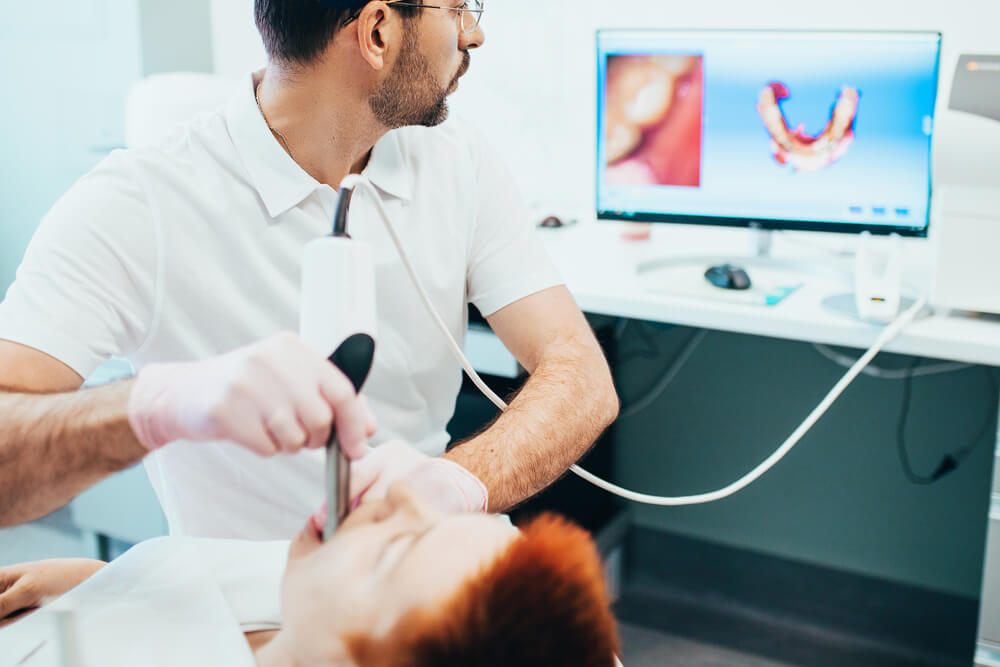 Dentist scans jaw and creates a 3D model on computer. 