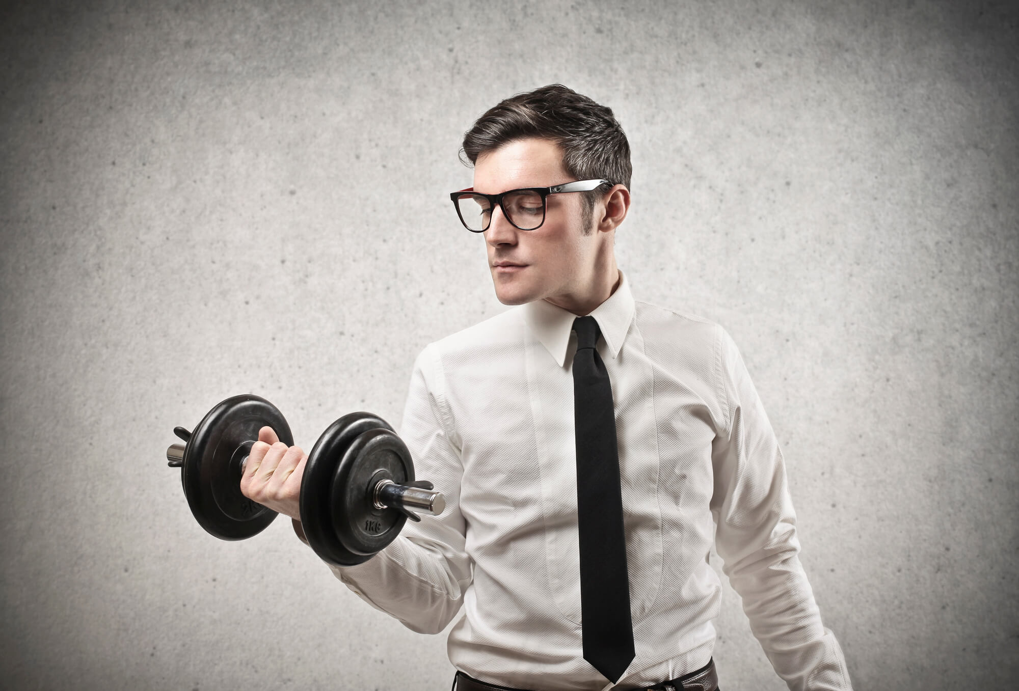 young businessman holding a dumbbell 