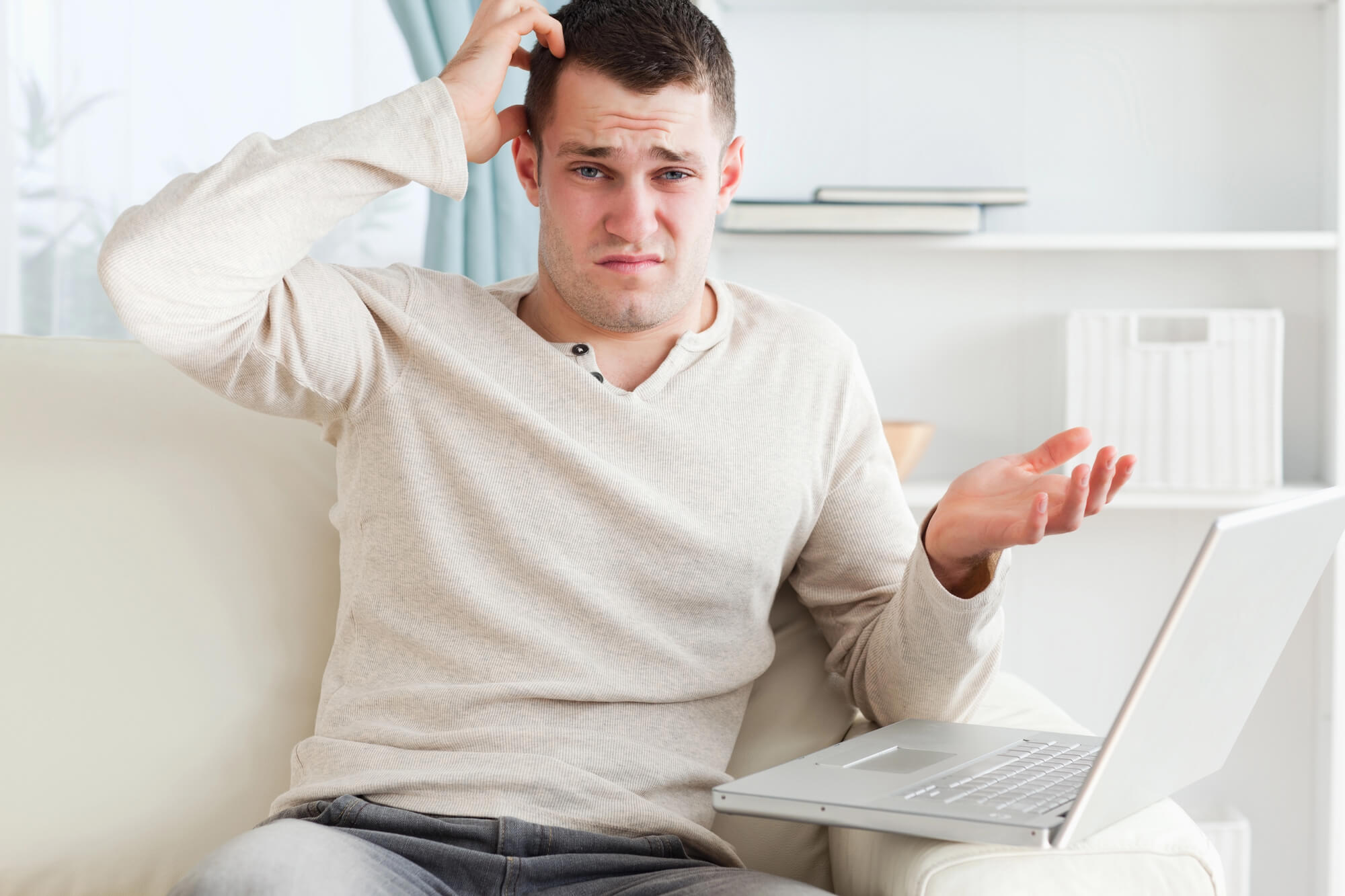 confused young man using a laptop 