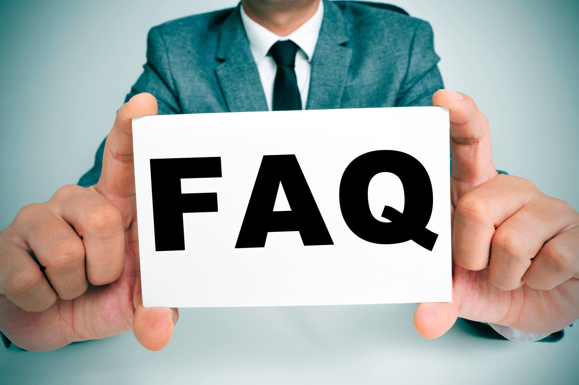 businessman holding faq sign