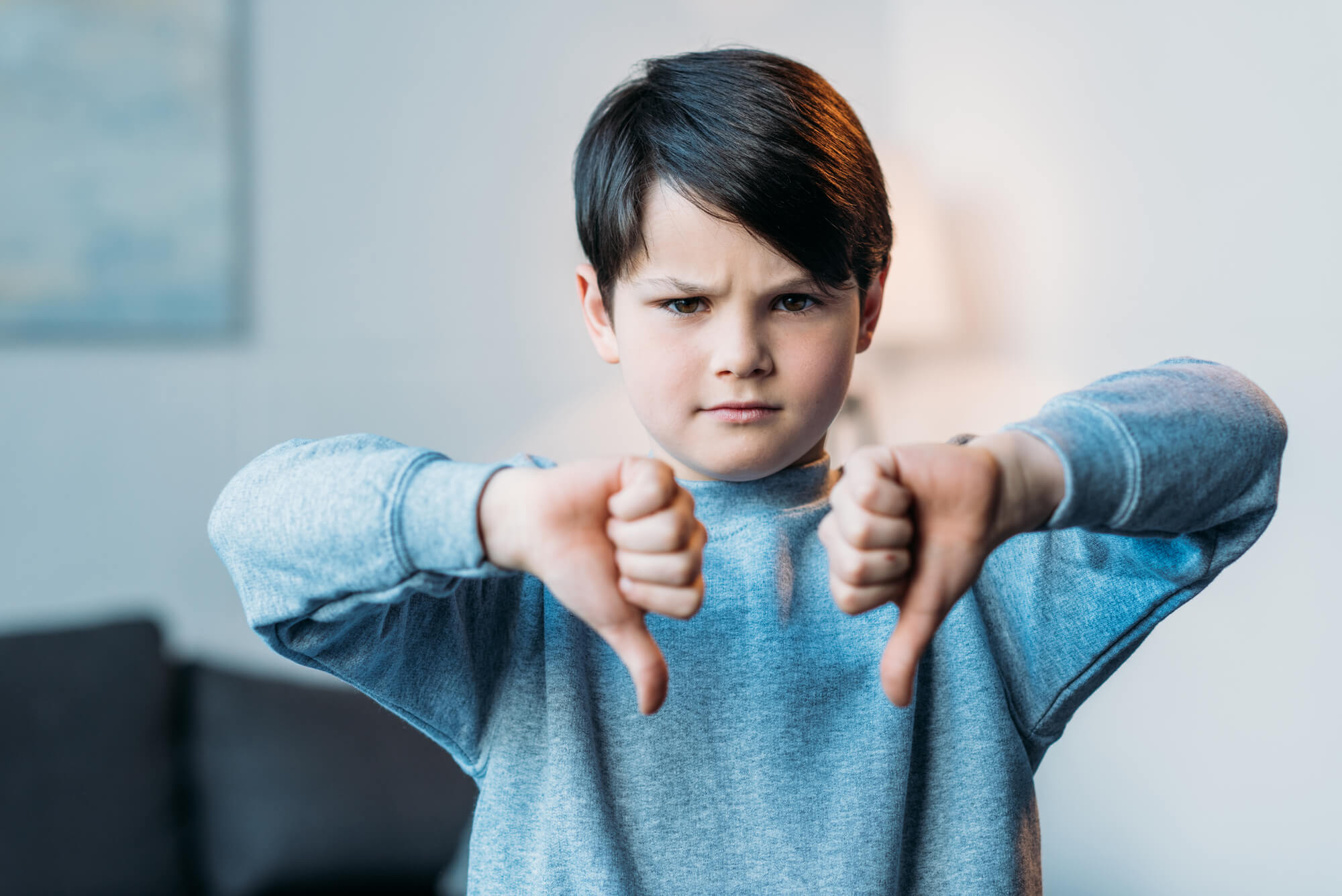 a child patient showing his thumbs down